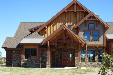 Aménagement d'une grande façade de maison multicolore montagne à un étage avec un revêtement mixte, un toit à quatre pans et un toit en shingle.