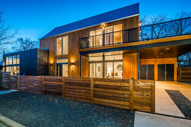 Example of a mid-sized trendy two-story wood house exterior design in Austin with a metal roof