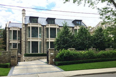 Large transitional gray two-story stone exterior home idea in Toronto with a metal roof