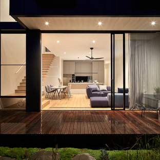 Imagen de fachada de casa negra, moderna, de tamaño medio, de dos plantas, con revestimiento de metal, tejado plano y tejado de metal