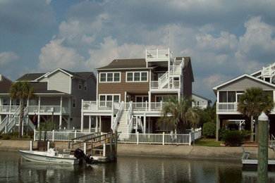 Example of a large beach style brown three-story wood exterior home design in Other