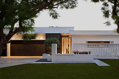 Immagine della facciata di una casa bianca contemporanea con rivestimenti misti e tetto piano