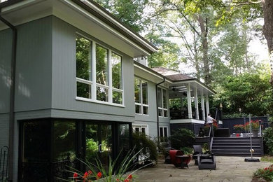 Inspiration for a mid-sized contemporary gray three-story mixed siding exterior home remodel in Raleigh with a hip roof