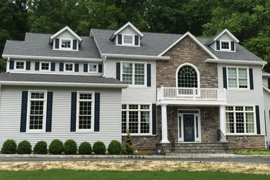 Huge traditional gray two-story vinyl exterior home idea in New York