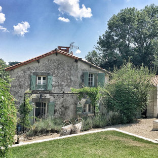 Aménagement d'une façade de maison grise campagne à un étage avec un toit à deux pans et un toit en tuile.