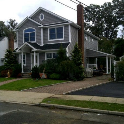 Example of a large classic gray two-story vinyl gable roof design in New York