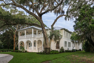 Large mediterranean beige two-story mixed siding house exterior idea in Jacksonville with a hip roof and a tile roof
