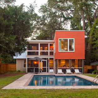 Inspiration pour une façade de maison rouge minimaliste de taille moyenne et à un étage avec un revêtement en panneau de béton fibré et un toit de Gambrel.