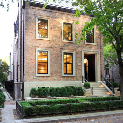 Transitional red two-story brick exterior home idea in Chicago with a metal roof