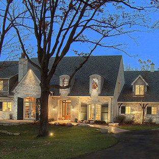 Example of a large classic beige two-story stone exterior home design in Chicago with a shingle roof