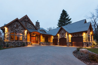 Design ideas for a large and gey rustic bungalow detached house in Calgary with stone cladding, a pitched roof and a shingle roof.