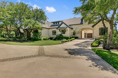 Huge transitional beige two-story stone exterior home photo in Austin with a tile roof