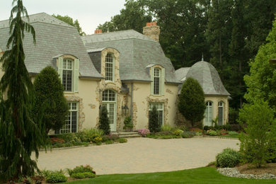 Large french country beige two-story stucco house exterior idea in New York with a hip roof and a tile roof