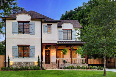 Large french country beige two-story house exterior photo in Houston with a shingle roof