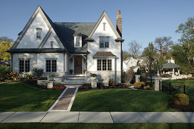 Inspiration pour une grande façade de maison beige traditionnelle en stuc à deux étages et plus avec un toit à deux pans.