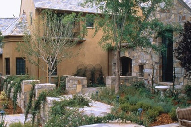 Inspiration for a mid-sized mediterranean beige two-story adobe house exterior remodel in Las Vegas with a clipped gable roof and a shingle roof