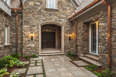 Example of a classic two-story stone exterior home design in Minneapolis