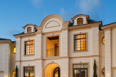 Diseño de fachada beige clásica de tres plantas