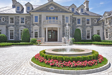 Example of a huge classic gray three-story stone house exterior design in New York with a hip roof and a shingle roof