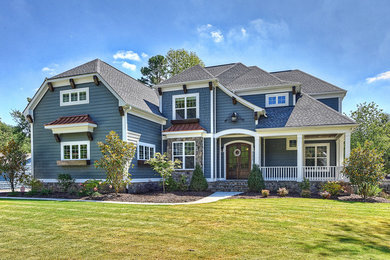 Large transitional blue two-story house exterior idea in Other with a clipped gable roof and a shingle roof