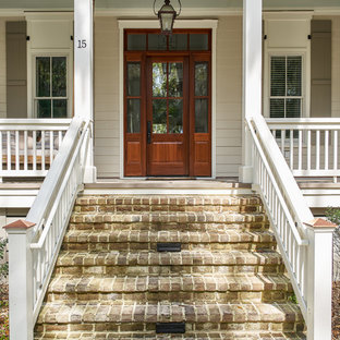 Example of a large beach style beige two-story wood house exterior design in Charleston with a shingle roof