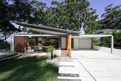 Medium sized and brown contemporary two floor detached house in Sydney with wood cladding, a flat roof and a metal roof.