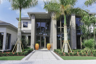 Large minimalist gray two-story concrete house exterior photo in Miami with a hip roof and a shingle roof