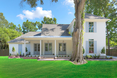 Großes, Zweistöckiges Landhaus Einfamilienhaus mit Faserzement-Fassade, weißer Fassadenfarbe, Walmdach und Schindeldach in New Orleans