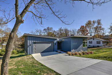 На фото: двухэтажный, синий частный загородный дом среднего размера в стиле ретро с комбинированной облицовкой, односкатной крышей и металлической крышей с