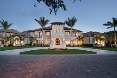 Example of a transitional two-story stucco exterior home design in Miami