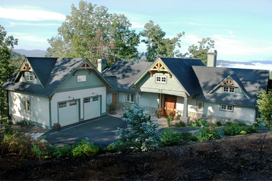 Modelo de fachada de casa verde de estilo americano de tamaño medio de dos plantas con revestimiento de aglomerado de cemento, tejado a dos aguas y tejado de teja de madera
