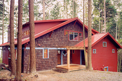 Diseño de fachada roja campestre a niveles con revestimiento de madera