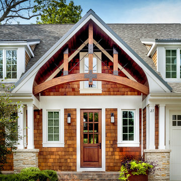 Front entry gable detail with rustic arched beams and iron brackets