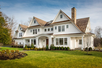 Example of a classic white three-story wood house exterior design in New York with a shingle roof