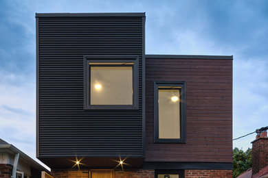 Пример оригинального дизайна: двухэтажный, черный дом в современном стиле с комбинированной облицовкой и плоской крышей