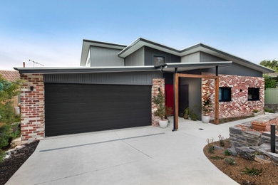 Medium sized and gey contemporary two floor brick detached house in Canberra - Queanbeyan with a lean-to roof and a metal roof.