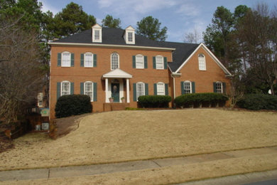 Mid-sized elegant brown three-story brick exterior home photo in Atlanta with a hip roof