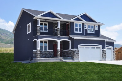 Diseño de fachada de casa azul de estilo americano grande de dos plantas con revestimiento de estuco, tejado a dos aguas y tejado de teja de madera