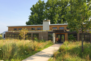 Inspiration for a large modern brown one-story wood house exterior remodel in Other with a metal roof and a shed roof