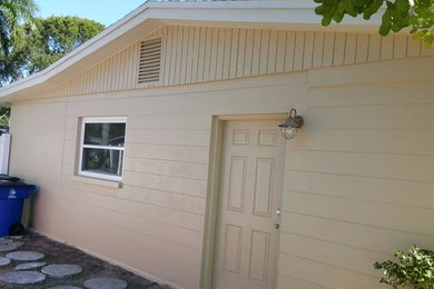 Medium sized and beige classic bungalow house exterior in Miami with vinyl cladding and a pitched roof.