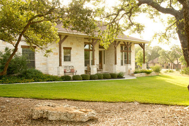 Example of a large mountain style white two-story stone gable roof design in Austin