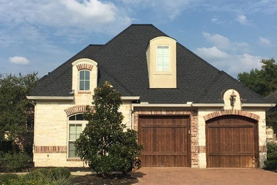 Inspiration for a mid-sized timeless beige house exterior remodel in Austin with a shingle roof