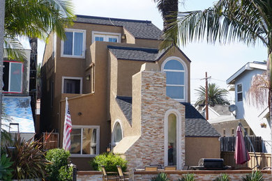 Mid-sized southwest brown three-story stucco exterior home photo in Orange County with a shingle roof