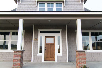 Modelo de fachada de casa gris de estilo americano grande de dos plantas con revestimientos combinados, tejado a dos aguas y tejado de teja de madera