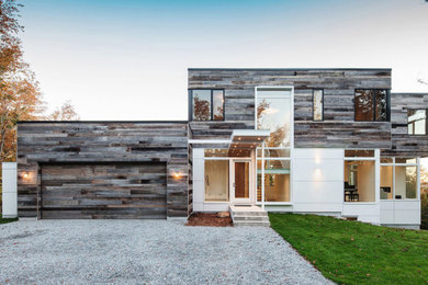 Imagen de fachada de casa gris contemporánea de dos plantas con revestimientos combinados y tejado plano
