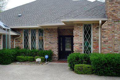 Photo of a large and red classic bungalow brick house exterior in Dallas with a hip roof.