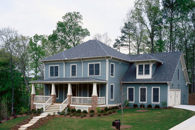 Ejemplo de fachada azul clásica renovada grande de dos plantas con revestimiento de madera y tejado a dos aguas