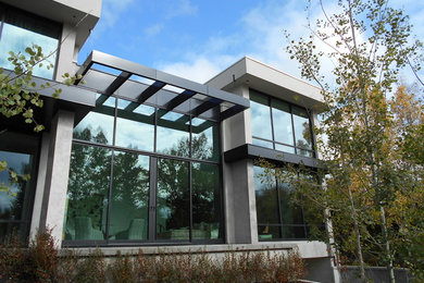Huge modern white two-story stucco flat roof idea in Calgary
