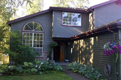 Cette image montre une façade de maison traditionnelle en bois de taille moyenne et à un étage avec un toit à deux pans.