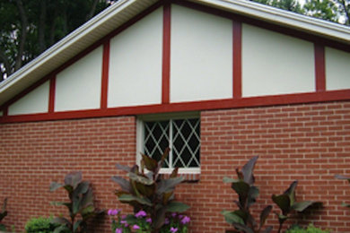 Einstöckiges Haus mit Backsteinfassade und roter Fassadenfarbe in Sonstige